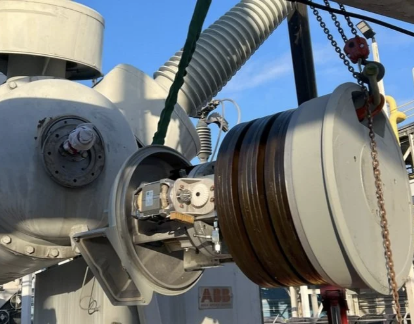Close-up of high-voltage breaker mechanism during SF6 leak inspection and maintenance